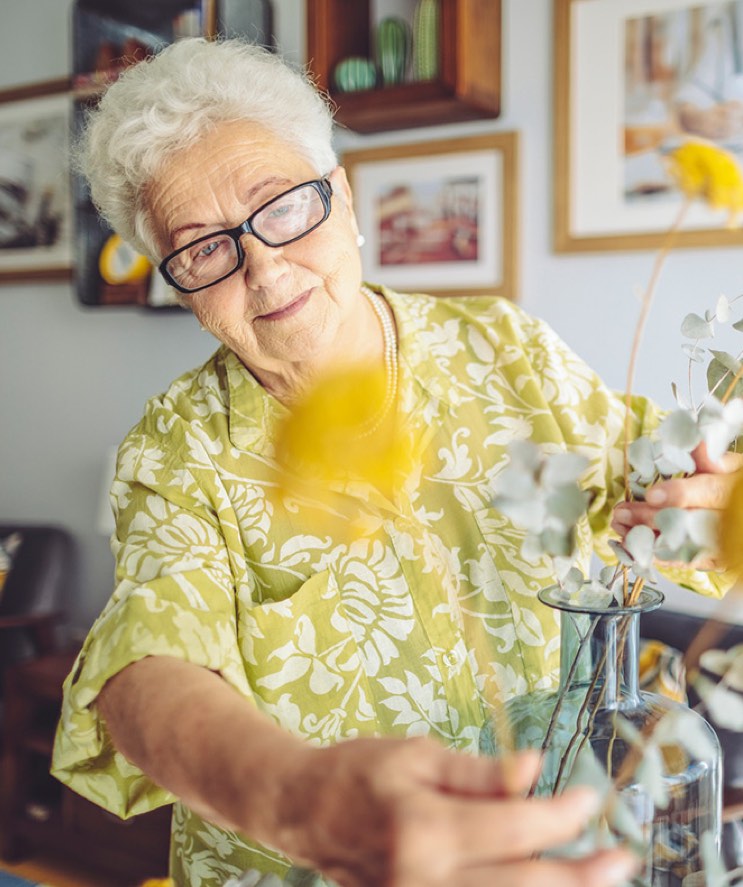 Woman adjust flower arrangement.