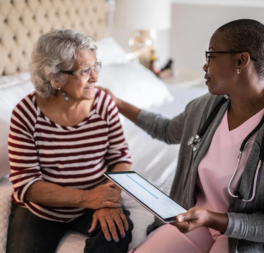 Nurse places hand on senior woman's shoulder