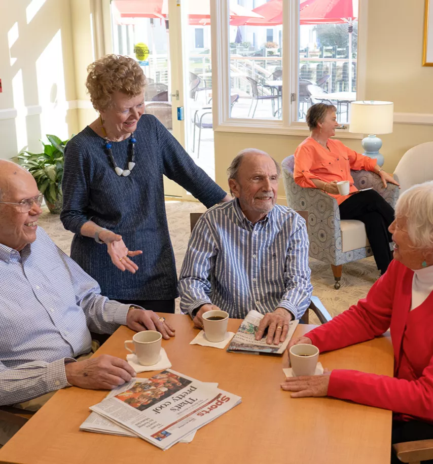 Group of seniors at Ginger Cove enjoying coffee and chatting.