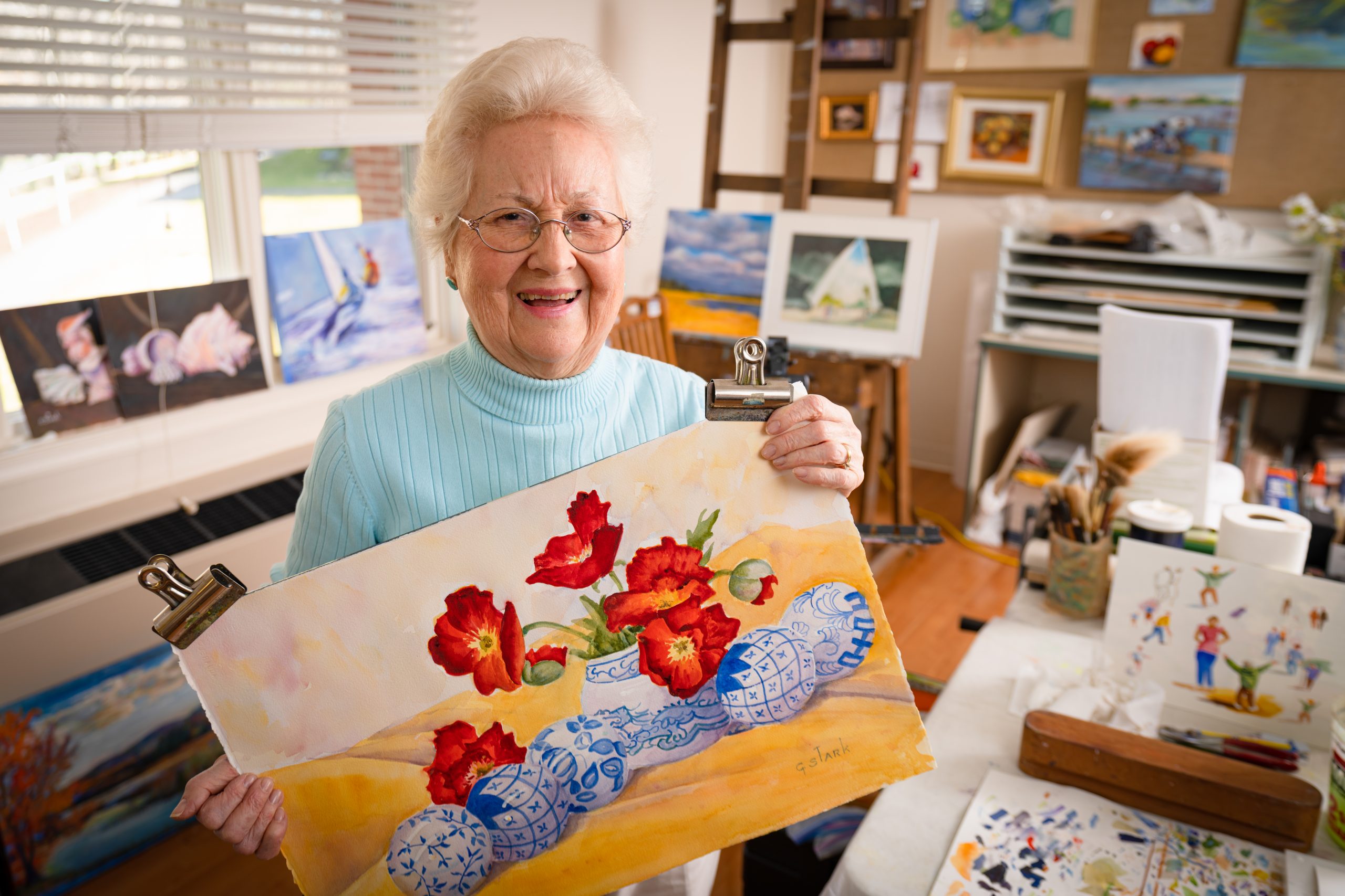 A women showing her painting at Ginger Cove. 