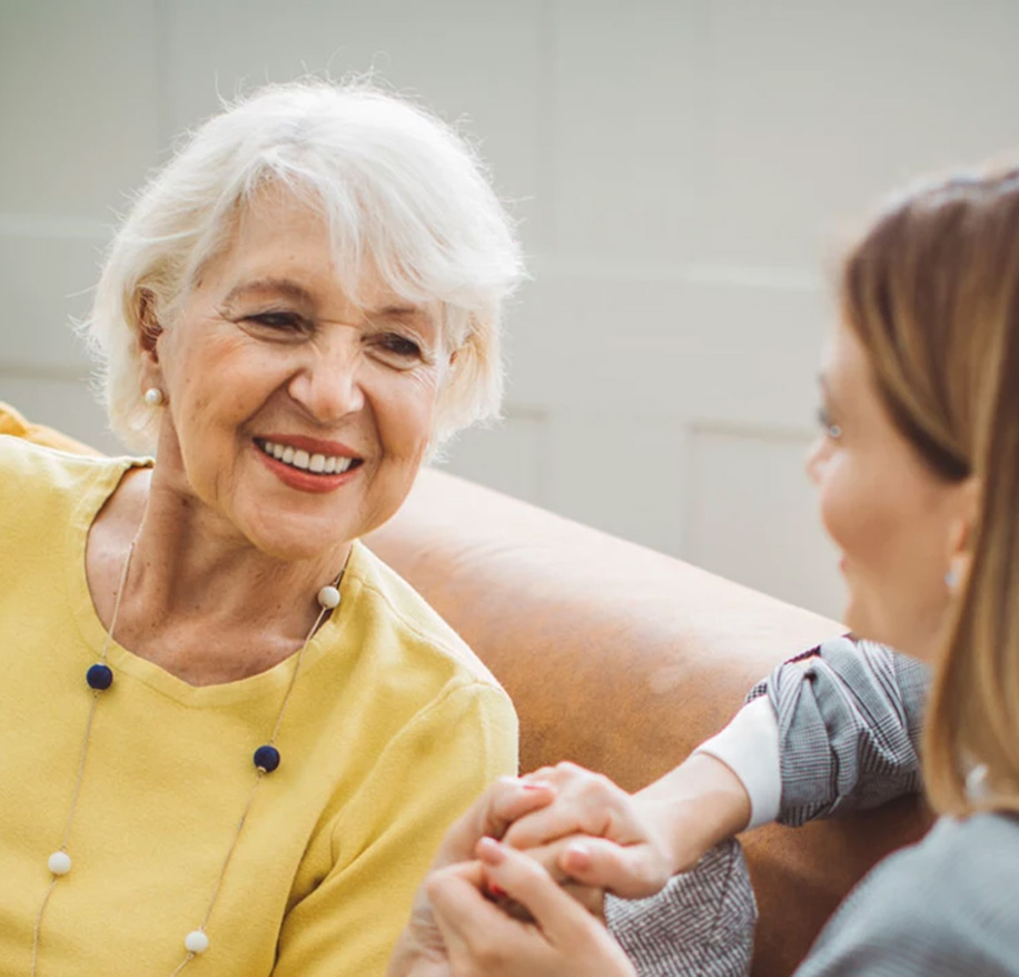 Senior woman smiles at caretaker.