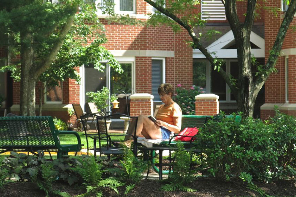 Ginger Cove resident reading a book outdoors on sunny summer day