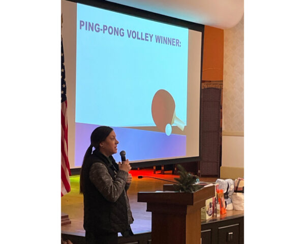 Ginger Cove employee announcing ping-pong volley winner